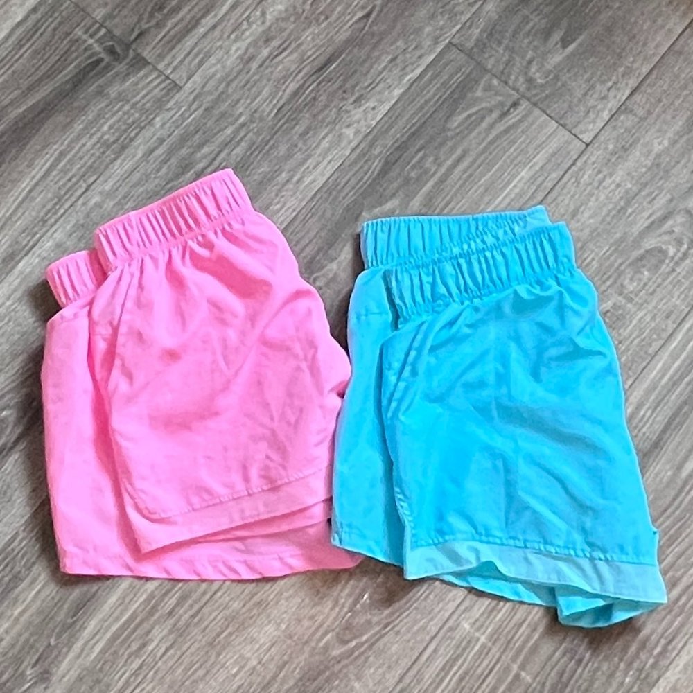 Bright pink or sky blue dri-fit running shorts with pockets and panty liner.